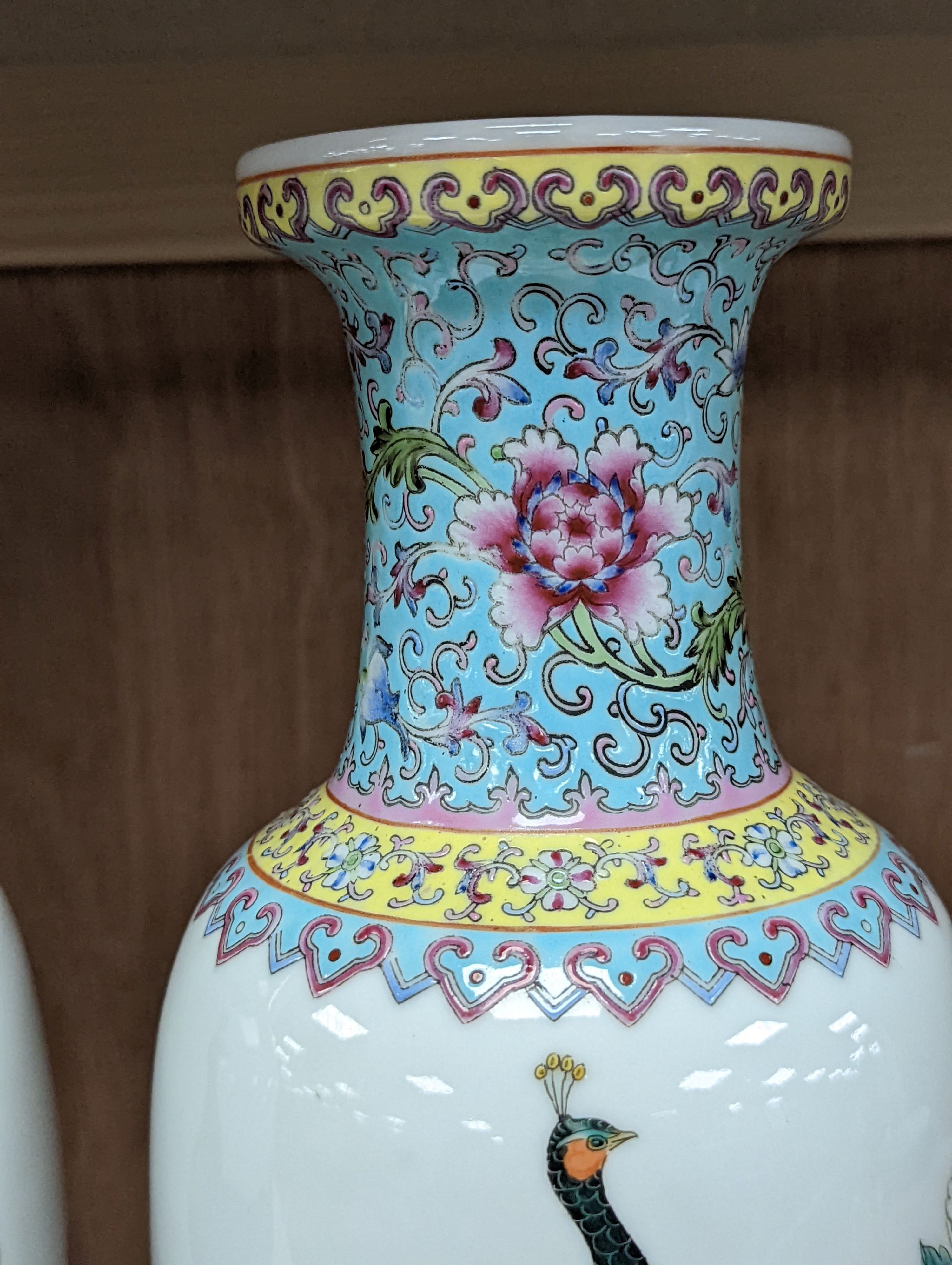 A pair of Chinese famille rose vases decorated with peacocks, 31cm